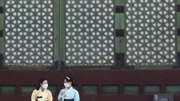 Women wearing face masks talk to each other at the Gyeongbok Palace in Seoul, South Korea on August 17. South Korea warned on August 17 of a looming novel coronavirus crisis as new outbreaks flared, including one linked to a church where more than 300 members of the congregation have been infected but hundreds more are reluctant to get tested. (Ahn Young-joon / AP)