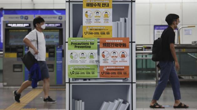 People wearing face masks pass by posters about precautions against the coronavirus at a subway station in Seoul on August 18. The Korea Centers for Disease Control and Prevention (KCDC) reported 246 new cases as of midnight on August 18, mostly in the Seoul metropolitan area, marking the fifth day of a three-digit tally. (Ahn Young-joon / AP)