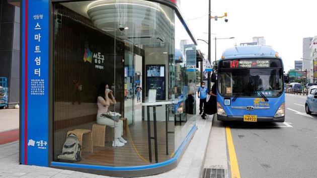 A woman wears a mask inside a glass-covered bus stop in which a thermal imaging camera, UV sterilizer, air conditioner, CCTV and digital signage are set, to avoid the spread of COVID-19 in Seoul on August 14. South Korea has been one of the world’s coronavirus mitigation success stories but it has nevertheless battled persistent spikes in infections. The latest cases brought its total infections to 15,761 including 306 deaths. (Heo Ran / REUTERS)