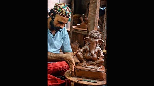 Potter Yusuf Zakaria Galwani takes measurements while working on a Ganesha clay idol at his workshop in Kumbharwada, Mumbai on August 15. “As our pottery sales dwindled, I decided to make Ganesha statues... as a means of survival and also to promote environmentally friendly (alternatives),” Galwani told AFP. (Indranil Mukherjee / AFP)