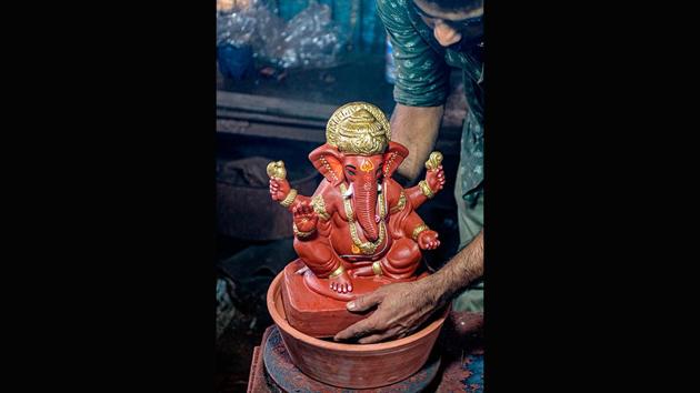 A potter checks the size of an immersion pot for a clay Ganesha idol at Galwani’s workshop in Kumbharwada on August 15. Galwani’s clay creations are designed to disintegrate quickly and turn into soil. They also contain a seed inside which can germinate if watered like a plant. Sold for 1,500 rupees each, Galwani has received orders for 800 statues so far and hopes to see his neighbourhood bounce back economically after tackling the virus. (Indranil Mukherjee / AFP)