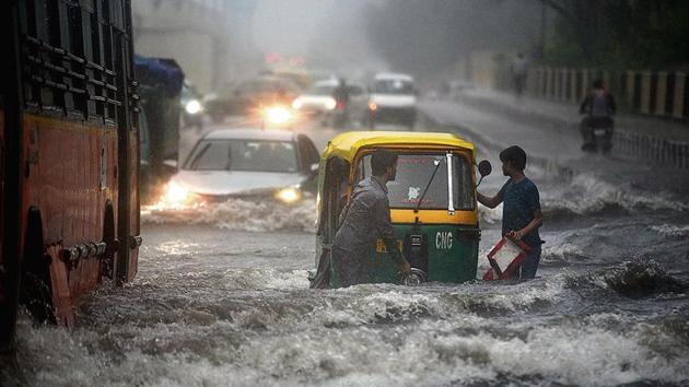 An auto breaks down on a waterlogged road in east Delhi on Monday(Ajay Aggarwal /HT Photo)