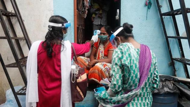 Community health volunteers check the temperature of a woman during a coronavirus check-up camp in Mumbai on August 16. Pattiwar added that there should be a system for regular interaction between doctors from semi urban and rural areas with the members of task force formed to reduce Covid-19 casualties, which is not happening. (Francis Mascarenhas / REUTERS)