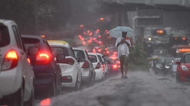A man uses an umbrella while walking on a pavement amid rain showers, at Kirti Nagar, in New Delhi on August 19. Heavy rainfall lashed various parts of Delhi-NCR on August 19, and the region witnessed long traffic snarls due to water logging, HT reported. (Sanchit Khanna / HT Photo) A man uses an umbrella while walking on a pavement amid rain showers, at Kirti Nagar, in New Delhi on August 19. Heavy rainfall lashed various parts of Delhi-NCR on August 19, and the region witnessed long traffic snarls due to water logging, HT reported. (Sanchit Khanna / HT Photo)