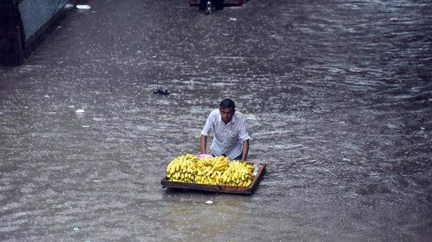 A banana seller pushes his cart through a water logged road under a railway bridge in New Delhi on August 19. Light to moderate showers were witnessed between 6 am to 8:30am, after which the intensity increased and so did the flooding in most low lying areas across Delhi-Gurgaon-Noida. (Raj K Raj / HT Photo) A banana seller pushes his cart through a water logged road under a railway bridge in New Delhi on August 19. Light to moderate showers were witnessed between 6 am to 8:30am, after which the intensity increased and so did the flooding in most low lying areas across Delhi-Gurgaon-Noida. (Raj K Raj / HT Photo)