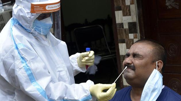 A health worker collects a swab sample for a Covid test in Lucknow.(Dheeraj Dhawan/HT Photo)