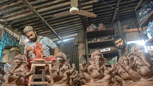 Potter Yusuf Zakaria Galwani (L) along with his colleague, works on the idols Hindu deity Ganesha at his workshop in Kumbharwada, Dharavi, Mumbai on August 15. After the coronavirus pandemic hit his pottery business, Galwani turned to a Hindu god to revive his fortunes by making environmentally-friendly Ganesha idols for the upcoming Ganesh Chaturthi festival. (Indranil Mukherjee / AFP)
