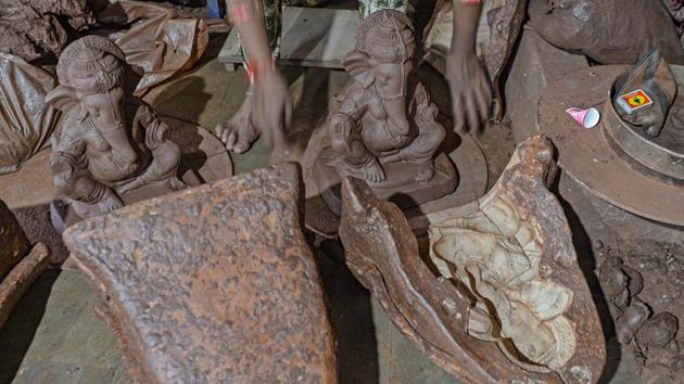 A potter takes out a Ganesh idol from a mould at Galwani’s workshop in Kumbharwada, Mumbai on August 15. Potter Galwani works with his two brothers in the Mumbai’s Dharavi to create 13-inch-tall statues out of terracotta clay. (Indranil Mukherjee / AFP)