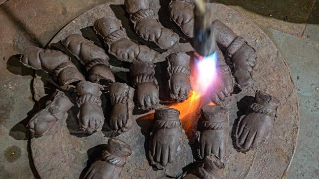 A potter uses a blowtorch to dry the hands of Ganesha clay idols at Galwani’s workshop in Kumbharwada, Mumbai on August 15. This year’s Ganesh Chaturthi celebrations are expected to be muted, with authorities in the virus plagued city urging people to mark the 10-day festival at home in a bid to ensure social distancing. (Indranil Mukherjee / AFP)