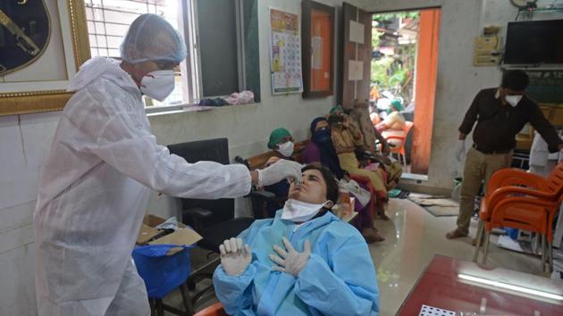 A health worker collects swab sample of a doctor post duty at a testing camp in Mumbai on August 17. There is also a growing concern of inadequate coronavirus specialized staff amid surging cases. “We need specialised staff to treat critical patients. Both the state and the Central government could not provide that quality of trained health staff and infrastructure in rural and semi-urban areas,” Dr Sanjay Pattiwar, a public health expert told HT. (Indranil Mukherjee / AFP)