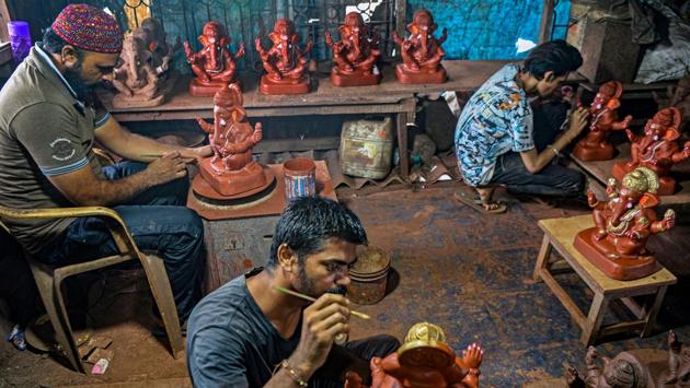 Potter Yusuf Zakaria Galwani (L) along with his staff, works on the clay idols Hindu deity Ganesha at his workshop in Kumbharwada, Mumbai on August 15. “Every year, we see huge Ganesha statues made from plaster of Paris washing up on the shores after the immersion. This affects our local environment and marine life as well,” Galwani said. (Indranil Mukherjee / AFP)