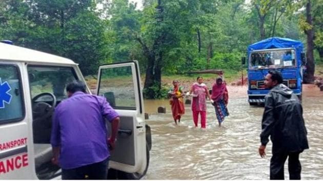 The tribal woman, Bharati crossing the nullah, along with ASHA workers after delivery. The tribal woman, Bharati crossing the nullah, along with ASHA workers after delivery.