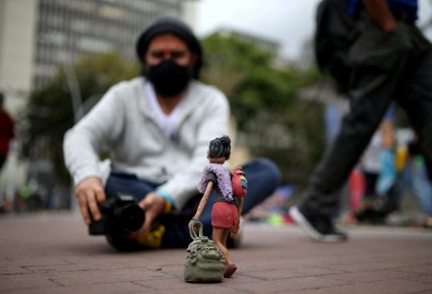 Colombian artist and creator of "I explain it with plasticine," Edgar Alvarez, wears a face mask as he takes pictures of his clay figure of a Venezuelan migrant, which he put on a sidewalk to photograph, amidst an outbreak of the coronavirus disease (COVID-19), in Bogota, Colombia August 7, 2020. (REUTERS) Colombian artist and creator of "I explain it with plasticine," Edgar Alvarez, wears a face mask as he takes pictures of his clay figure of a Venezuelan migrant, which he put on a sidewalk to photograph, amidst an outbreak of the coronavirus disease (COVID-19), in Bogota, Colombia August 7, 2020. (REUTERS)