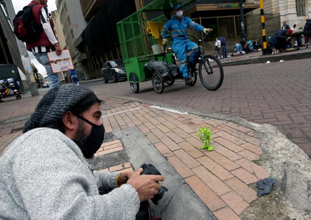Edgar Alvarez, Colombian artist and creator of "I explain it with plasticine," takes pictures of his clay figure of the microscopic view of the coronavirus, which he put on a sidewalk to photograph, amidst an outbreak of the coronavirus disease (COVID-19), in Bogota, Colombia August 7, 2020. (REUTERS) Edgar Alvarez, Colombian artist and creator of "I explain it with plasticine," takes pictures of his clay figure of the microscopic view of the coronavirus, which he put on a sidewalk to photograph, amidst an outbreak of the coronavirus disease (COVID-19), in Bogota, Colombia August 7, 2020. (REUTERS)