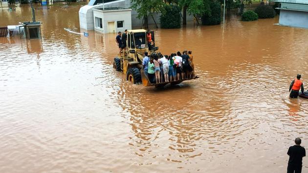 Rescuers evacuate residents using a loader in a flooded area in Leshan on August 18. More than 100,000 people have been evacuated from the flood-hit cities of Ya’an and Leshan, AFP reported citing Xinhua News Agency. (AFP)