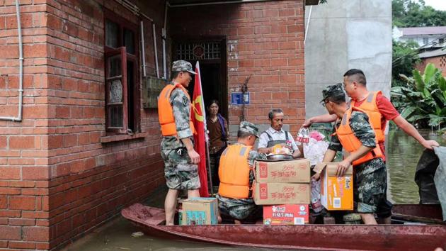 Community workers and volunteers deliver food and supplies to flood-affected residents in Neijiang region of Sichuan province on August 19. (AFP)
