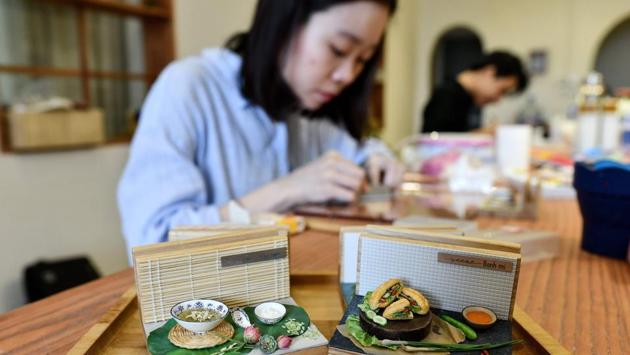 Nguyen Thi Ha An working at her studio in Hanoi. Ninety percent clay and 10 percent liquid plastic, the models can take up to five days each to make, and An sells them for up to $80. An’s assistant, 21-year-old Nguyen Ngan Ha, added that their work must be meticulous at every stage. “People must be able to believe this is real food,” she told AFP. (Manan Vatsyayana / AFP) Nguyen Thi Ha An working at her studio in Hanoi. Ninety percent clay and 10 percent liquid plastic, the models can take up to five days each to make, and An sells them for up to $80. An’s assistant, 21-year-old Nguyen Ngan Ha, added that their work must be meticulous at every stage. “People must be able to believe this is real food,” she told AFP. (Manan Vatsyayana / AFP)