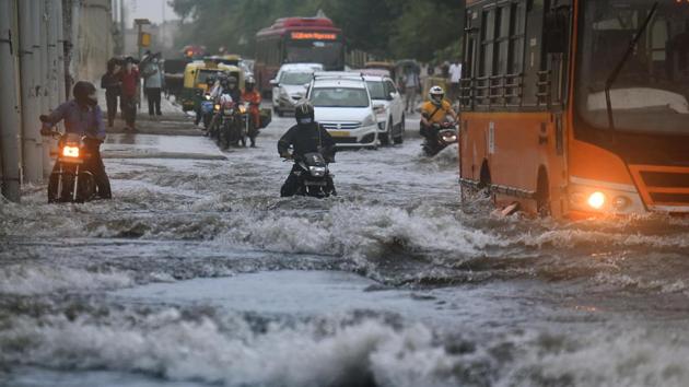 Commuters wade through a water-logged stretch of road, along NH-24, near Mayur Vihar, in New Delhi on Wednesday. (Raj K Raj/HT Photo) Commuters wade through a water-logged stretch of road, along NH-24, near Mayur Vihar, in New Delhi on Wednesday. (Raj K Raj/HT Photo)