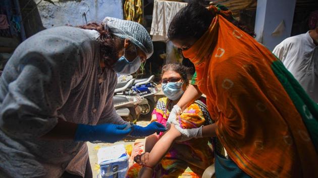 A medical worker collects a blood sample for the second serological survey sampling in early August in New Delhi.(Amal KS/HT Photo)
