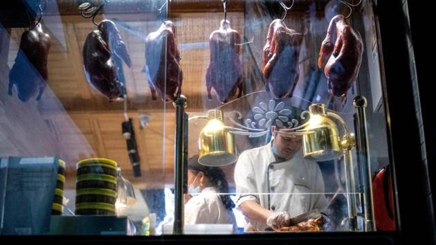 A chef slices a Peking duck at a restaurant in Beijing on August 20. China has reported no new locally transmitted cases on the mainland for five days after successfully controlling flare ups in the capital, Xinjiang and elsewhere. (Noel Celis / AFP)