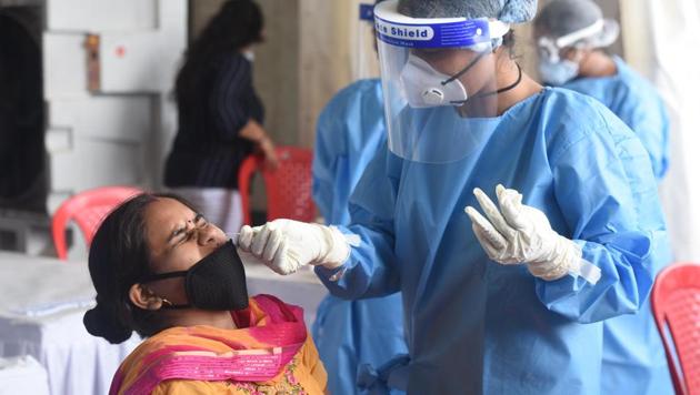 A health worker takes samples for Covid-19 rapid antigen tests at a testing facility for travellers at Anand Vihar Bus Terminal, in New Delhi.(Sonu Mehta/HT PHOTO)