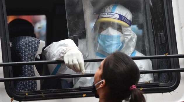 A health worker in PPE coveralls collects a swab sample from a woman to test for Covid-19 infection at Adarsh Nagar in New Delhion Thursday.(Sanchit Khanna/HT File Photo)