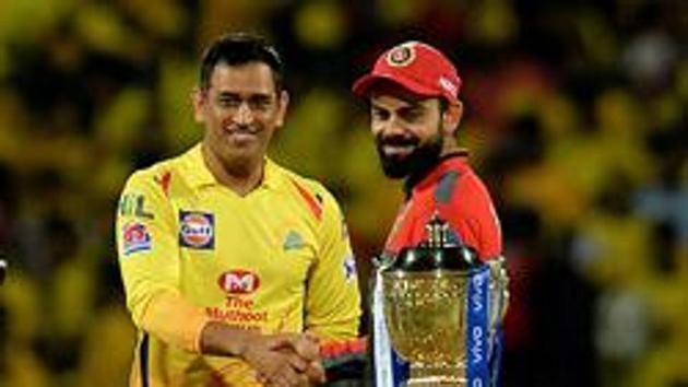 (FILES) In this file photo taken on March 24, 2019, Chennai Super Kings cricket captain Mahendra Singh Dhoni and Royal Challengers Bangalore cricket captain Virat Kohli (R) gesture beside IPL trophy(AFP)