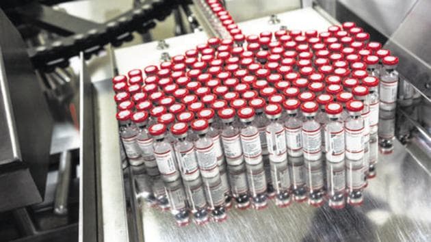 Vaccine vials exit a vaccine vial monitor labelling machine at the Serum Institute of India Ltd. pharmaceutical plant in Pune, Maharashtra.(Bloomberg File Photo)