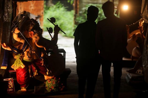 People walk past an idol of Lord Ganesh, the deity of prosperity, stepping on a coronavirus disease (COVID-19) replica before the start of the Ganesh Chaturthi festival in Mumbai, India, August 21, 2020. (REUTERS) People walk past an idol of Lord Ganesh, the deity of prosperity, stepping on a coronavirus disease (COVID-19) replica before the start of the Ganesh Chaturthi festival in Mumbai, India, August 21, 2020. (REUTERS)