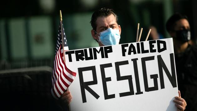 A protester wearing a protective mask attends the US President Donald Trump protest for him to resign, during a march to honor people who have died during the coronavirus disease (Covid-19) outbreak, in Brooklyn, New York.(REUTERS)