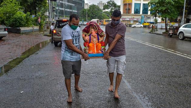 Two men carry a Ganesh idol to their home on the eve of Ganpati festival at Dadar in Mumbai.(PTI)