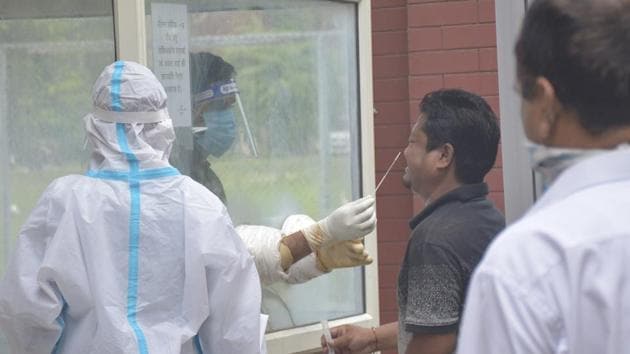 A health worker in PPE coveralls takes a swab sample from a man for coronavirus testing at IMS College in Ghaziabad.(Sakib Ali /Hindustan Times) A health worker in PPE coveralls takes a swab sample from a man for coronavirus testing at IMS College in Ghaziabad.(Sakib Ali /Hindustan Times)