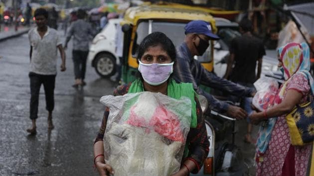 A woman carries a rapped up idol of God Ganesha in a plastic sheet to save from rains. (AP Photo) A woman carries a rapped up idol of God Ganesha in a plastic sheet to save from rains. (AP Photo)