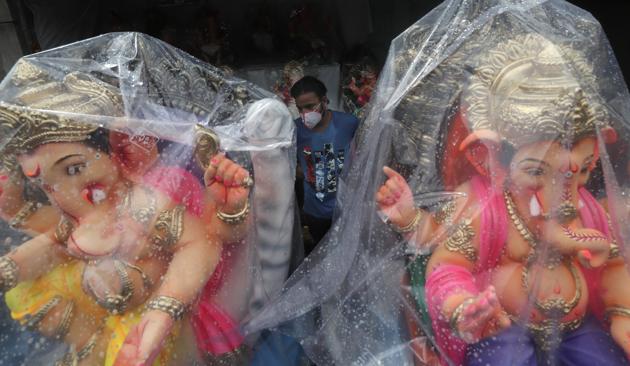 A devotee wearing a face mask shops for an idol of Lord Ganesha to take home for worship during Ganesh Chaturthi festival celebrations in Mumbai, India, Saturday, Aug. 22, 2020. (AP) A devotee wearing a face mask shops for an idol of Lord Ganesha to take home for worship during Ganesh Chaturthi festival celebrations in Mumbai, India, Saturday, Aug. 22, 2020. (AP)