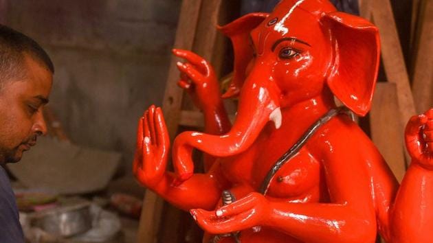 An artisan gives final touch to idol of Lord Ganesha.(PTI)