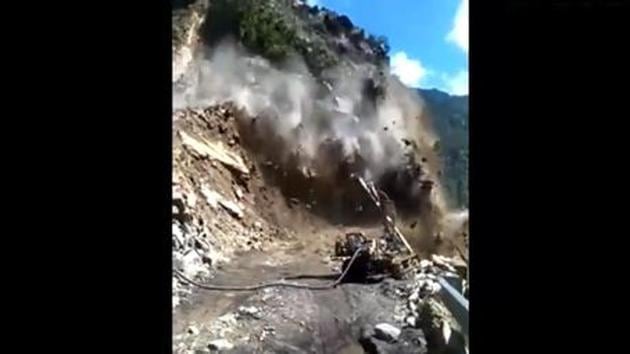 Seen in the video, the crowd rushes towards safety as a patch of the mountain on a stretchy, narrow road comes crashing down.(Screengrab/ANI)