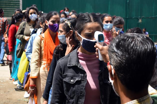 College staff checking the body temperature of students appearing foe exams in Shimla on Saturday. (Deepak Sansta / HT) College staff checking the body temperature of students appearing foe exams in Shimla on Saturday. (Deepak Sansta / HT)