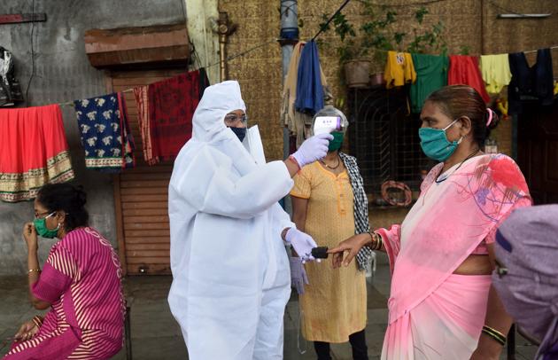 A health care worker checks the temperature of a woman in Mumbai this file photo. (Satish Bate/HT Photo) A health care worker checks the temperature of a woman in Mumbai this file photo. (Satish Bate/HT Photo)