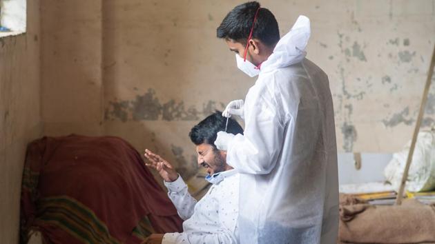 A man grimaces in reaction to a nasal swab fro rapid antigen testing at Cheetah Camp in Mumbai on August 21. India’s journey to two million cases took 158 days, with at least 90% of these cases coming after the lifting of the nationwide lockdown that was announced at the end of March. India’s current case positivity rate, which gives the number of cases that return positive out of all the samples that are tested, is about 8%. (Pratik Chorge / HT Photo)