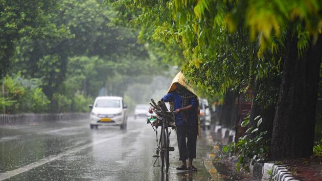 A commuter pushes his cycle under rain near Adchini in New Delhi on August 19. Delhi starts recording monsoon rain from June 1 and September 30 is considered the monsoon retreating date. The peak for rainfall activity is recorded between July 15 and the first week of August . However, the monsoon officially arrived in Delhi this year only on July 24. (Amal KS / HT Photo )