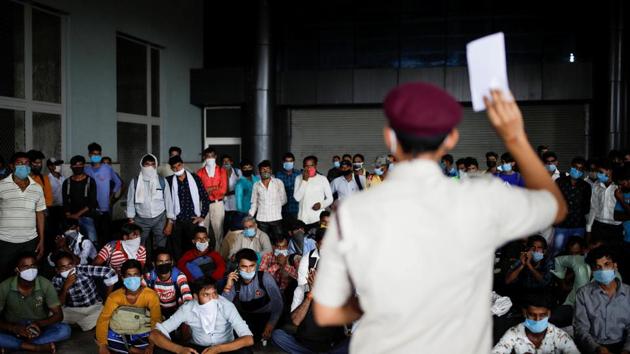 Migrant workers, who returned to Delhi from their native state, wait for their rapid antigen test report, at a bus terminal, amidst the coronavirus disease (Covid-19) outbreak in New Delhi.(REUTERS)