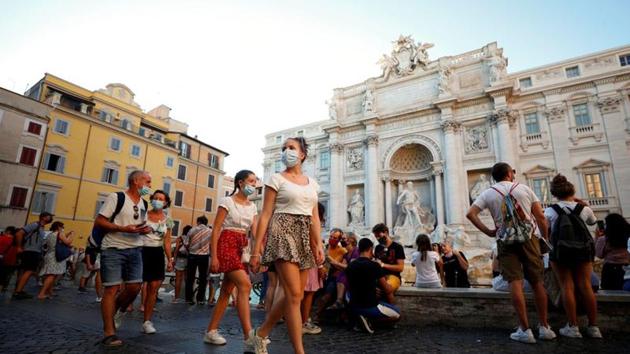 People wearing face masks walk in front of the Trevi Fountain following a government decree that states face coverings must be worn between 6 p.m. and 6 a.m. near bars and pubs and in areas where gatherings are more likely, due to the coronavirus disease outbreak, in Rome, Italy. (REUTERS) People wearing face masks walk in front of the Trevi Fountain following a government decree that states face coverings must be worn between 6 p.m. and 6 a.m. near bars and pubs and in areas where gatherings are more likely, due to the coronavirus disease outbreak, in Rome, Italy. (REUTERS)