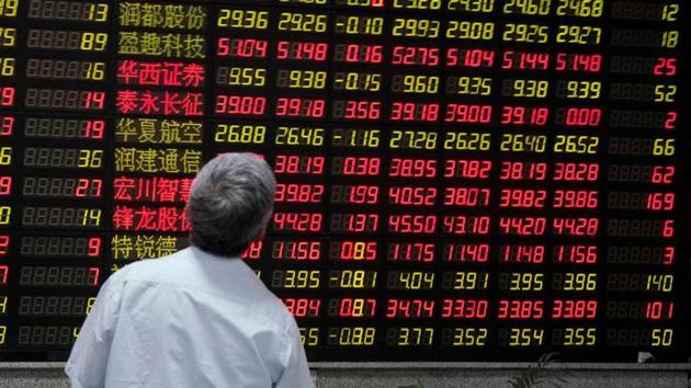 A man looks at an electronic board showing stock information at a brokerage house in Shanghai, China.(Reuters File Photo)
