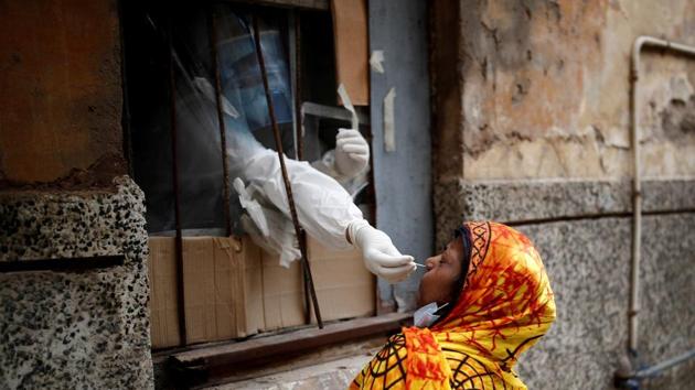 A health worker in personal protective equipment (PPE) collects a sample using a swab from a person at a local health centre to conduct tests for the coronavirus disease.(REUTERS)