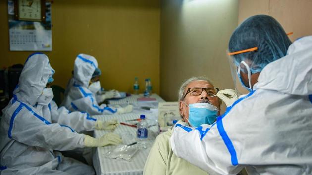 A Kolkata Municipal Corporation health worker collects swab sample of a resident for Covid-19 test on August 23.(PTI)