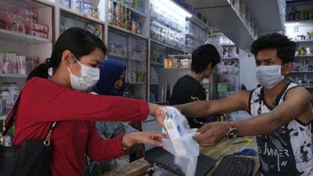 A girl buys surgical masks in Imphal, capital of Manipur.(AP)