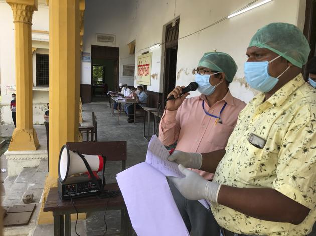 Health workers brief people who tested positive after a Covid-19 test in Prayagraj, India.(AP)