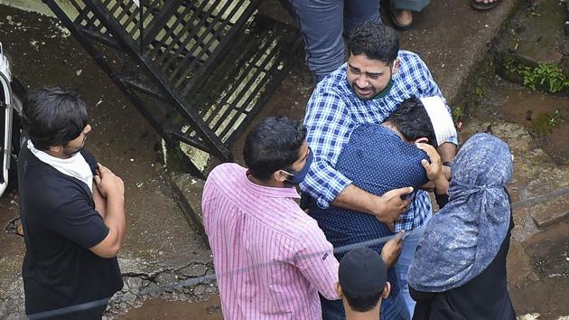 People console each other at the site of the building collapse, in Mahad on Tuesday.(PTI) People console each other at the site of the building collapse, in Mahad on Tuesday.(PTI)