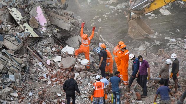 Rescue personnel sift through the rubble in search of survivors at the site where a five-storey apartment building collapsed, in Mahad in Raigad district.(PTI)