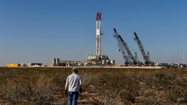 An oil worker walks towards a drill rig after placing ground-monitoring equipment in the vicinity of the underground horizontal drill in Loving County, Texas.(REUTERS)